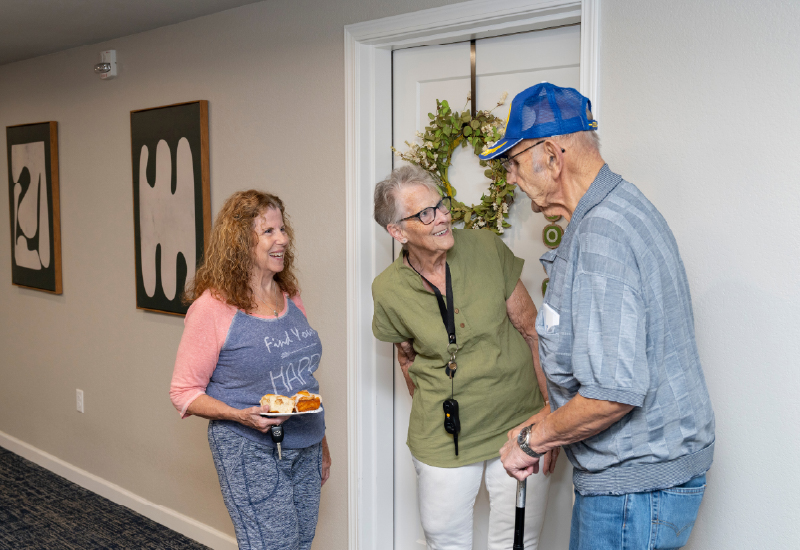 Three people having a conversation in a hallway.