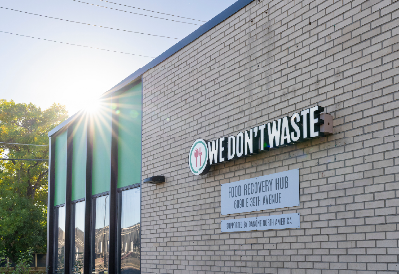 External photo of a brick building with a sign that reads We Don't Waste