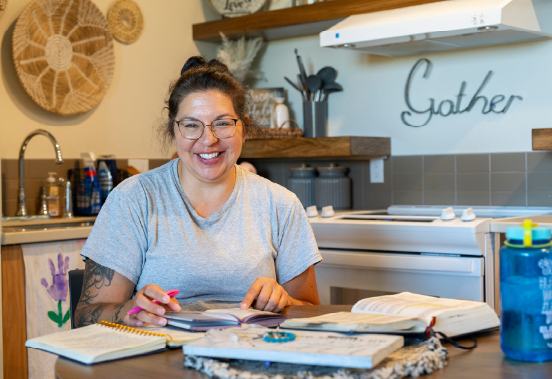 A person sitting at a kitchen table smiling