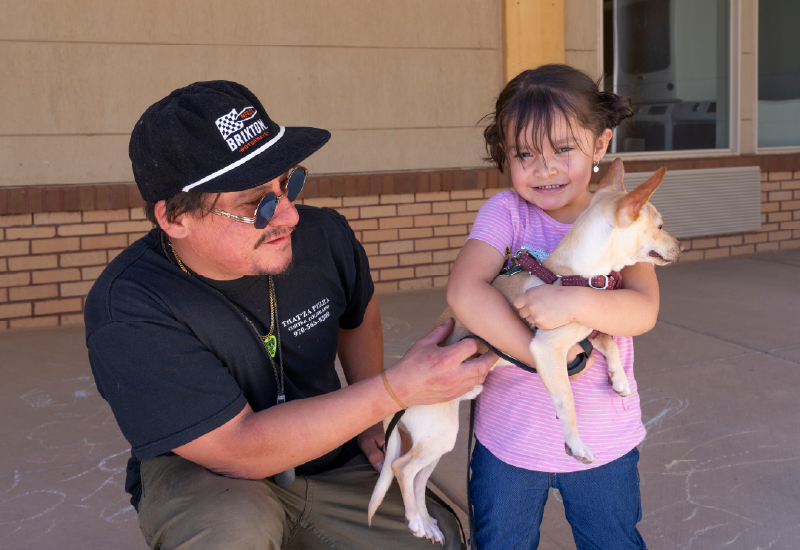 Two people with a small dog