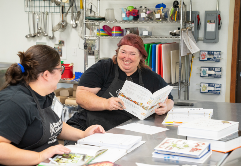 Two kitchen staff having a discussion in the kitchen