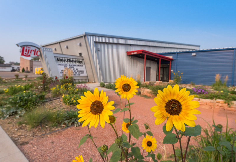 An image of The Lyric theater with sunflowers in the foreground 