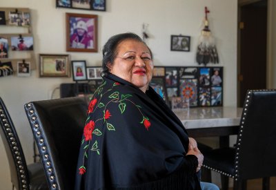 Bernadette Cuthair photo in front of family photos on the wall