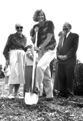 a black and white photo of Grace Buckley digging with a shovel at a groundbreaking