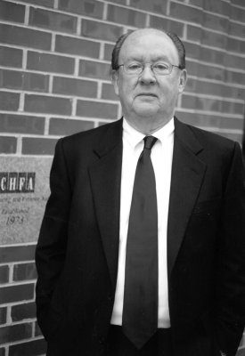 a black and white photo of David W. Herlinger standing in front of a building