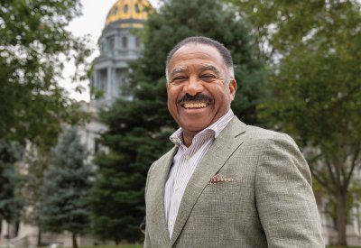 Penfield Tate III smiling while standing in front of the Colorado capitol