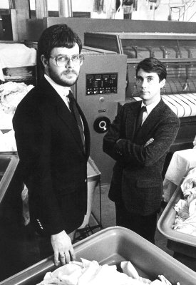 a black and white photo of Craig Archibald standing with another person