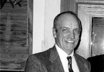 a black and white photo of Dave Barba smiling at the camera