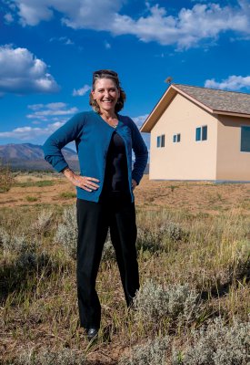 Laura Lewis Marchino standing in front of a house