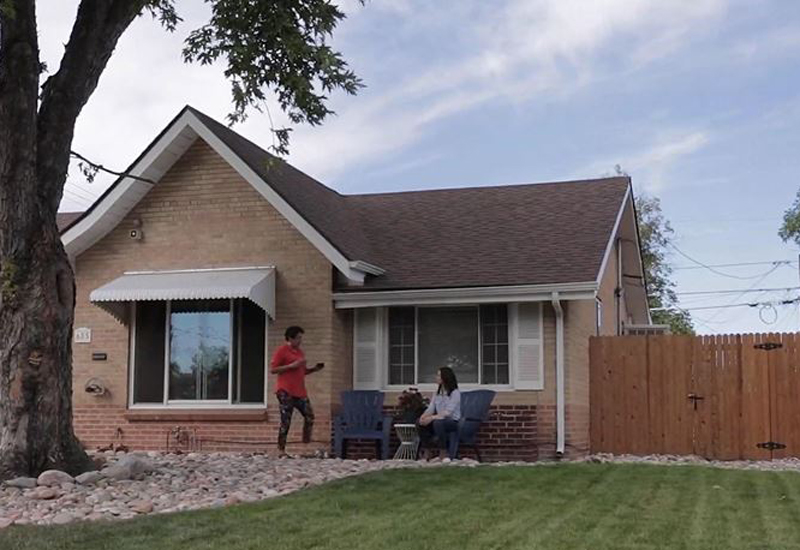 Exterior of home with two ladies sitting in chairs