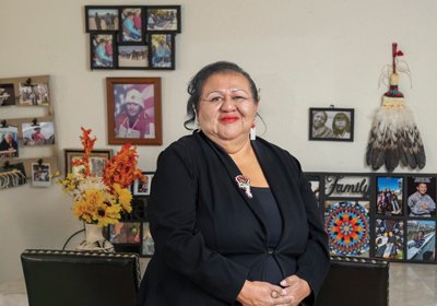 Bernadette Cuthair photo in front of family photos on the wall