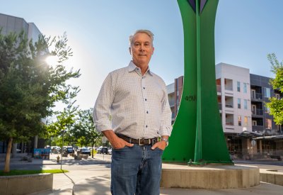 Craig Archibald standing outside with the sun behind him