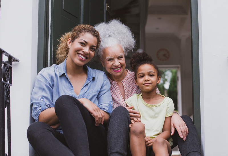 Three generations of women sitting a step