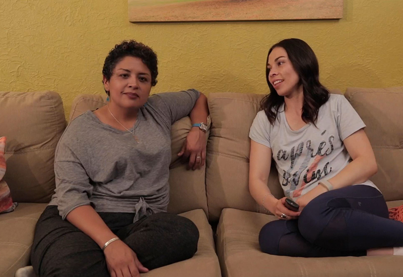 Two ladies sitting on couch together talking