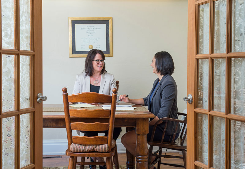 Two women facing each other at a desk