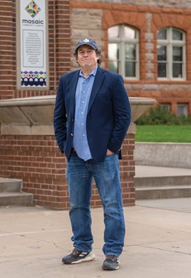 Aaron Miripol standing in front of a brick building