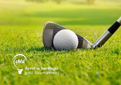 A golf ball and club with CHFA golf branding