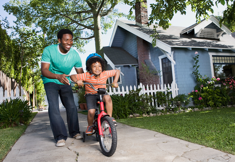 a father helping a child ride a bike