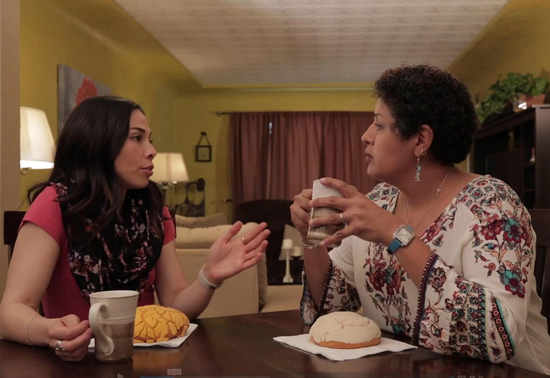 Two ladies sitting at kitchen table talking