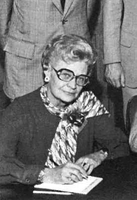 A black and white photo of Betty Ann Dittemore signing legislation