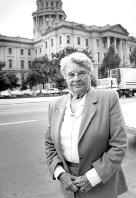 A black and white photo of Betty Ann Dittemore standing in front of the Colorado capitol