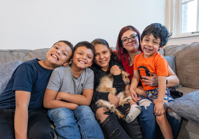 A group of children sitting on a couch smiling