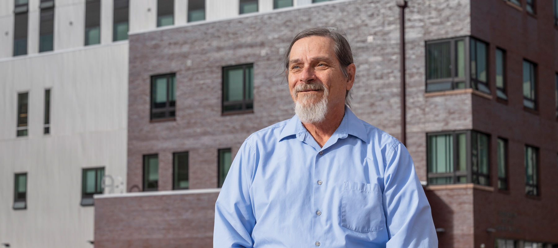 John Parvensky in a blue shirt in front of a large building