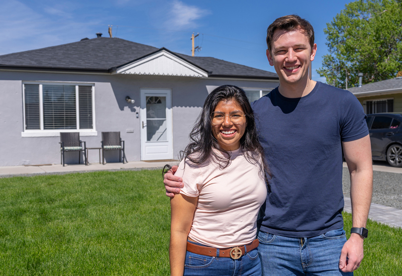 Brenda and Clayton standing in front of their home