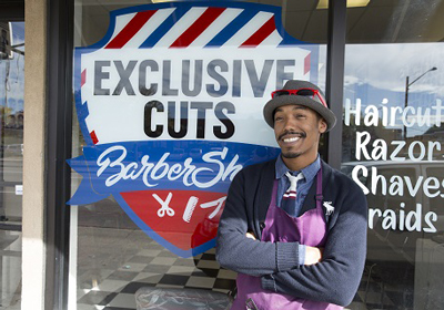 a barber in front of his window