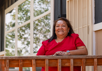 Woman on deck of home looking at camera