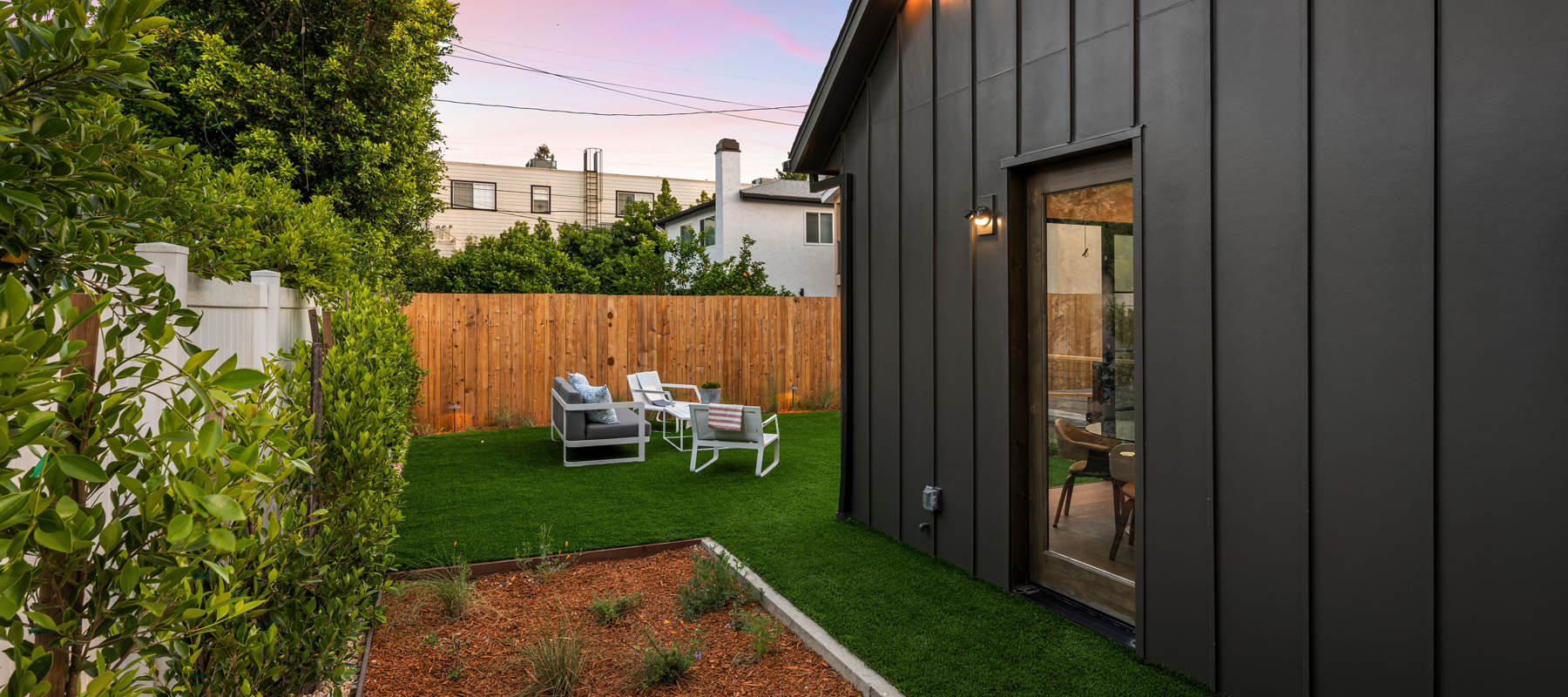 A backyard with an ADU on the right side.