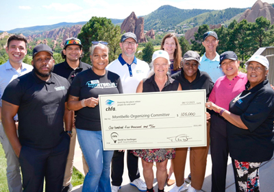 A group of people on a golf course holding a large check.