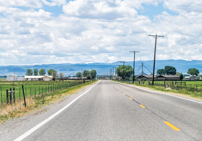 a rural road with mountains ahead