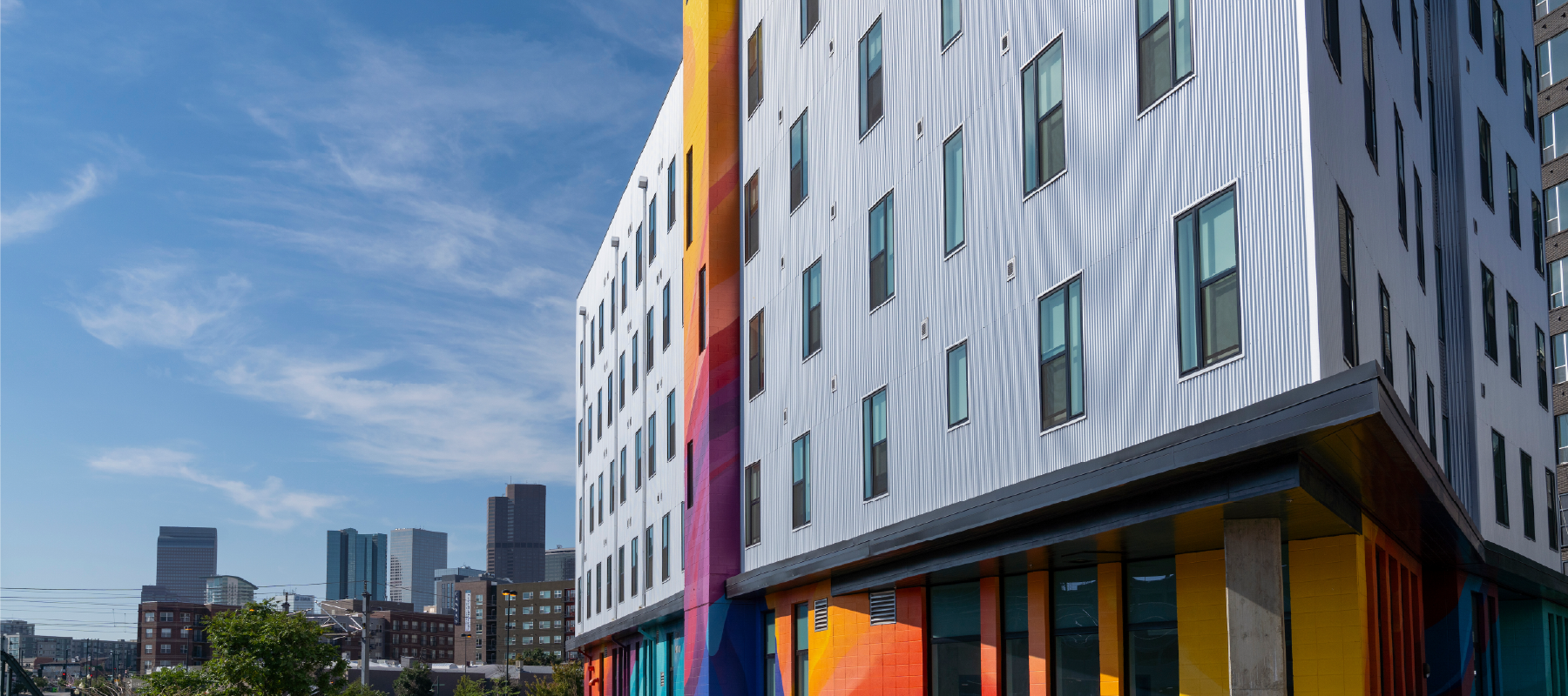 External view of a multi-story building in downtown Denver with bright color accents