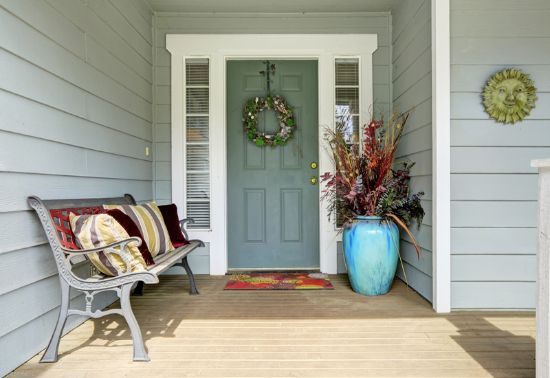 Front porch with bench and colorful potted plant