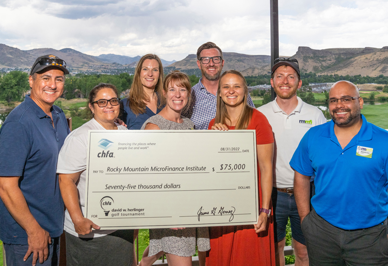 Rocky Mountain Microfinance Institute with CHFA Execs holding check